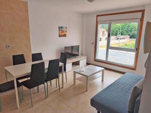 a living room with a table and chairs and a couch at Apartamentos Illa de Arousa 3000 in Isla de Arosa