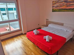 a bedroom with a bed with a red blanket at Apartamentos Illa de Arousa 3000 in Isla de Arosa