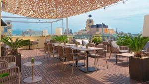 a patio with tables and chairs on a roof at H10 Universitat in Barcelona