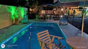 a pool with a chair and a table at Pousada Rota in Paty do Alferes