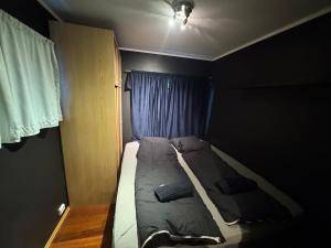 a bed in a small room with a window at Leilighet i Vadsoe sentrum in Vadsø