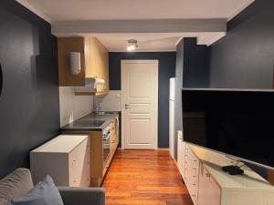 a small kitchen with black walls and a white door at Leilighet i Vadsoe sentrum in Vadsø