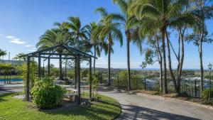 a park with a bench and palm trees at Lumina Motel Gladstone in Gladstone