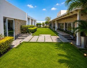 a yard of a house with green grass at weston Hotel And Resorts in kolkata