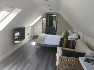 a bedroom with a bed and a couch in a room at Oaks Barn in Chinnor