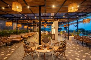 a restaurant with tables and chairs and a pool at TSG Emerald View Hotel and SPA in Port Blair
