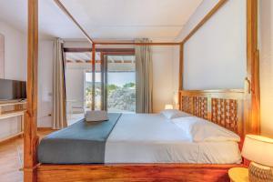 a bedroom with a bed with a view of the ocean at Hotel Delfino in Procchio