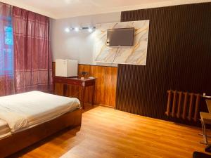 a bedroom with a bed and a tv on a wall at Ayanchin Hotel in Ulaanbaatar