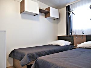 2 camas en una habitación con ventana en Auto kamp Cuka en Pakoštane