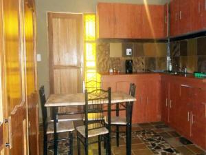 a kitchen with a table and chairs in a room at Emahlathini Guest Farm in Piet Retief