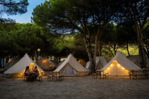 a group of tents with people sitting in front of them at Kampaoh Los Caños in Los Caños de Meca