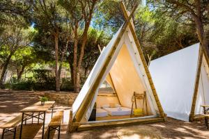 a tent with a bed and a table at Kampaoh Los Caños in Los Caños de Meca