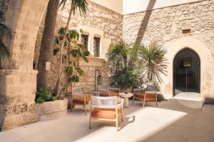 a patio with chairs and tables and a building at COOL DREAMS Luxury Rooms in Syracuse