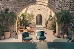 a courtyard with chairs and a swimming pool at COOL DREAMS Luxury Rooms in Syracuse