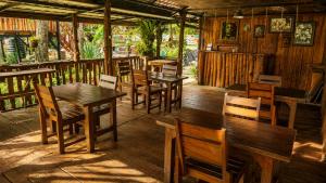 a restaurant with wooden tables and wooden chairs at Tetebatu Garden Lombok in Tetebatu