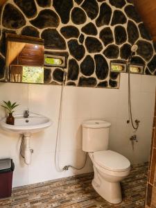 a bathroom with a toilet and a sink at Tetebatu Garden Lombok in Tetebatu