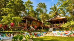 a resort with two cottages in a garden at Tetebatu Garden Lombok in Tetebatu