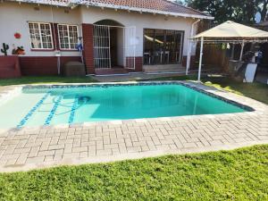 a swimming pool in front of a house at Villa Mexicana Guesthouse in Kimberley
