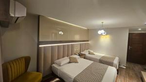 a hotel room with two beds and a chair at Aura Garden City Hotel in Cairo