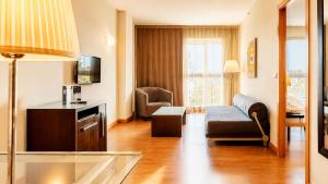 a living room with a couch and a chair at Vértice Sevilla in Seville
