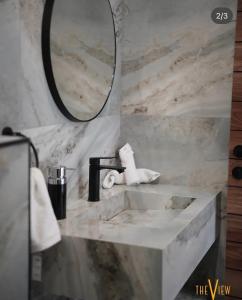 a bathroom with a sink and a mirror at THE VIEW chalet in Makhrabā +6 photos