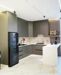 a kitchen with a black refrigerator and gray cabinets at THE VIEW chalet in Makhrabā
