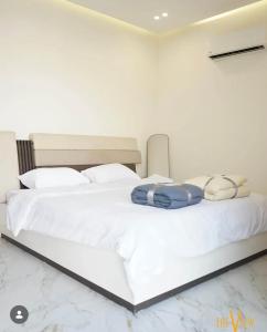 a bedroom with a bed with white sheets and pillows at THE VIEW chalet in Makhrabā
