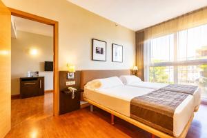 a bedroom with a bed and a large window at Vértice Sevilla in Seville +52 photos