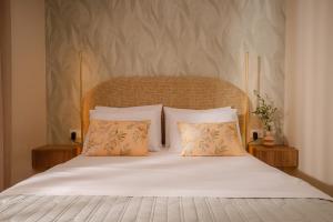 a bed with white sheets and two pillows at Seamar View Zante in Argassi