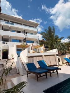 a resort with blue chairs and a swimming pool at SunSeaBar Beach Resort in Kendwa
