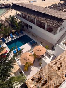 an aerial view of a hotel with a swimming pool and umbrellas at SunSeaBar Beach Resort in Kendwa