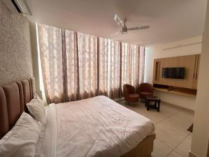 a bedroom with a bed and a tv in a room at Vida Hotel in Patiāla