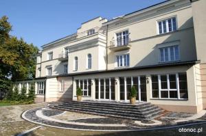 a large white building with steps in front of it at Aviator Hotel in Radom