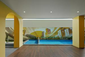 a room with a mural of a city and a swimming pool at Kampi Hotel Sunter in Jakarta