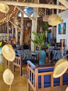 a restaurant with tables and chairs in a room at Marafiki Bungalows in Kiwengwa