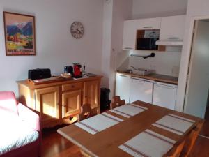 a living room with a table and a kitchen at Résidence Vignec Village by Actisource in Vignec