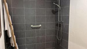 a bathroom with a shower with gray tiles at Hostal La Riera de Peratallada in Peratallada