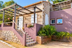 a house with a staircase in front of it at La Maison De Stephanie in Porto-Vecchio