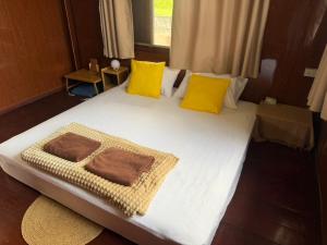 a large white bed with yellow pillows in a room at taitoon hostel&cafe in Chiang Rai +15 photos