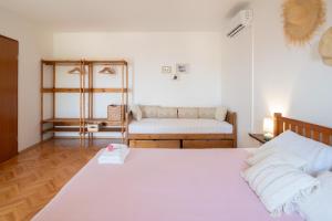 a bedroom with a white bed and a couch at More Garden in Opric