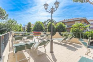 Eine Gruppe Stühle und eine Straßenlaterne auf einer Terrasse in der Unterkunft Hotel Fabrizio in Rimini
