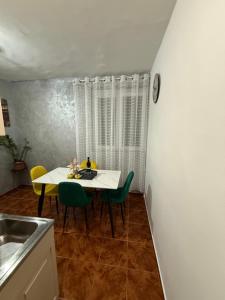 a dining room with a table and green chairs at Apartman Marković in Meljine