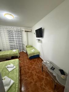 a room with two beds and a flat screen tv at Apartman Marković in Meljine