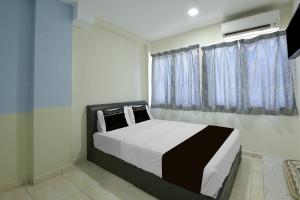 a bedroom with a bed and a window at Collection O Axlite Hotel in Taiping