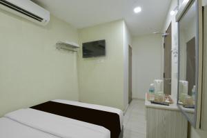 a hospital room with a bed and a mirror at Collection O Axlite Hotel in Taiping +30 photos