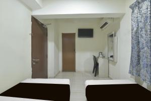 a small room with two beds and a door at Collection O Axlite Hotel in Taiping