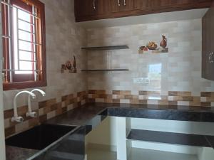 a kitchen with a sink and a counter top at Shanmikha Residency - Attur - Near Highways in Āttūr