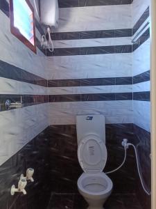 a bathroom with a white toilet and blue and white stripes at Shanmikha Residency - Attur - Near Highways in Āttūr +11 photos