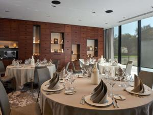 a dining room with tables with silverware and glasses at L'Esquisse Hotel & Spa Colmar - MGallery Collection in Colmar