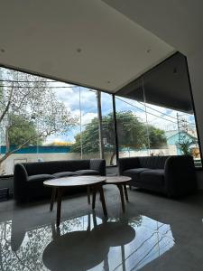 a living room with couches and tables and large windows at S by Z Hotels, HSR in Bangalore